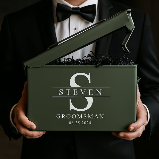 Man in tuxedo holding personalized olive green groomsman gift box with name and date